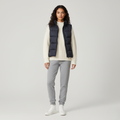 Navy padded gilet with stand collar worn open over a cream knit, front view